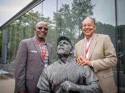 Attendees pose next to statue